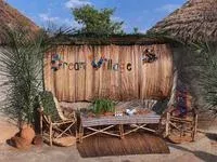 A handmade bamboo bench painted with Dream Village in the eco-lodging area